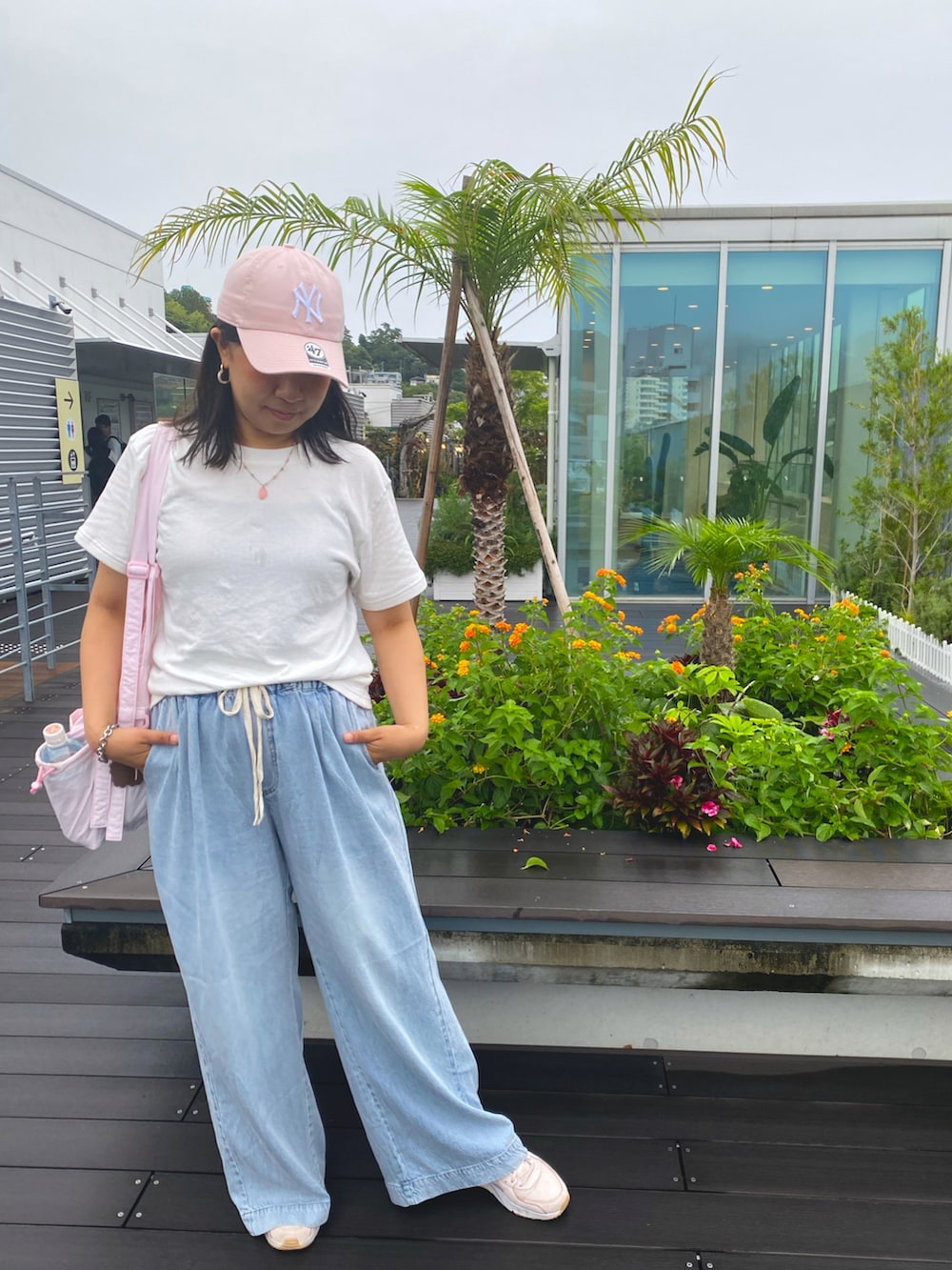 ブルー系のデニムパンツ、ホワイト系のTシャツ/カットソー、ピンク系のスニーカーを着用したレディースの秋コーディネートの2枚目の写真