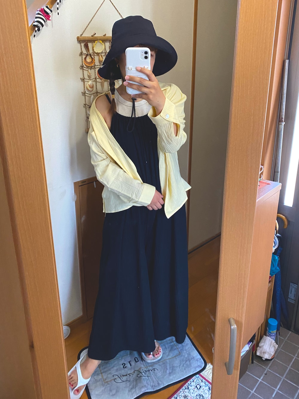 ブラック系のワンピース、ベージュ系のタンクトップ、イエロー系のシャツ/ブラウスを着用したレディースの夏コーディネートの2枚目の写真