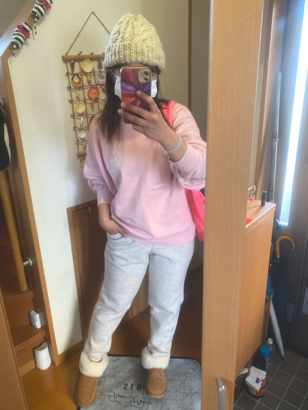 ピンク系のスウェット、ベージュ系のパンツ、ベージュ系のブーツを着用したレディースの冬コーディネートの2枚目の写真