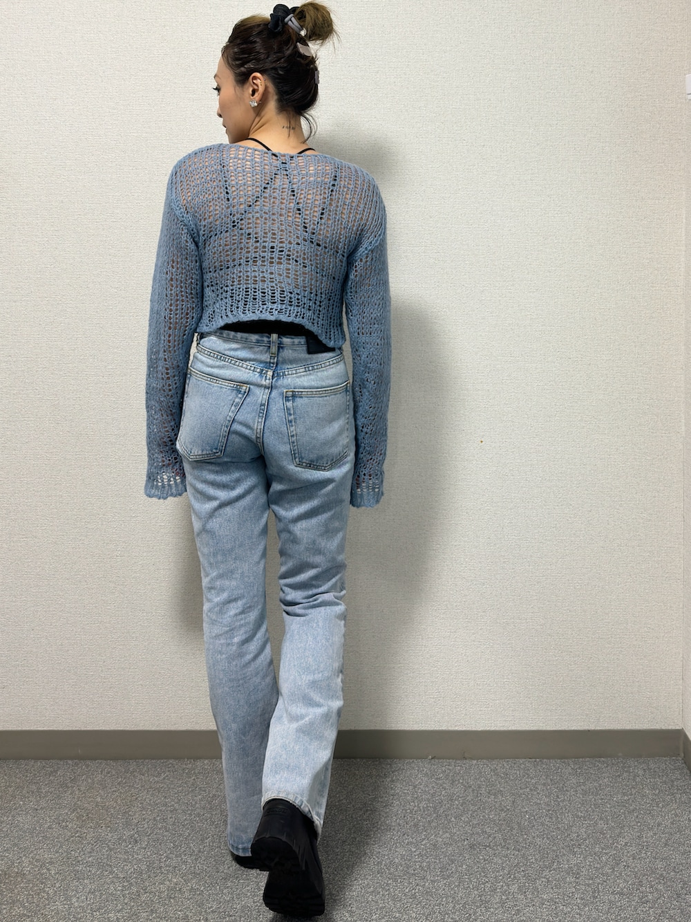 ブルー系のニット/セーター、ブルー系のデニムパンツ、ブラック系のブーツを着用したレディースの冬コーディネートの4枚目の写真