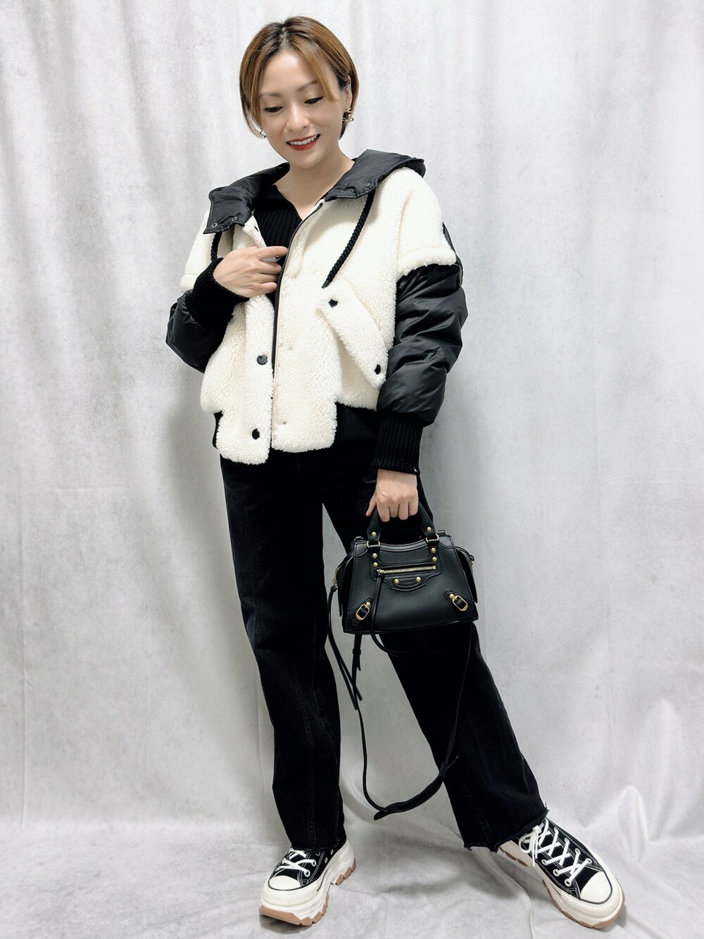 ブラック系のジャケット/アウター、ブラック系のバッグ、ブラック系のスニーカーを着用したレディースの冬コーディネートの3枚目の写真