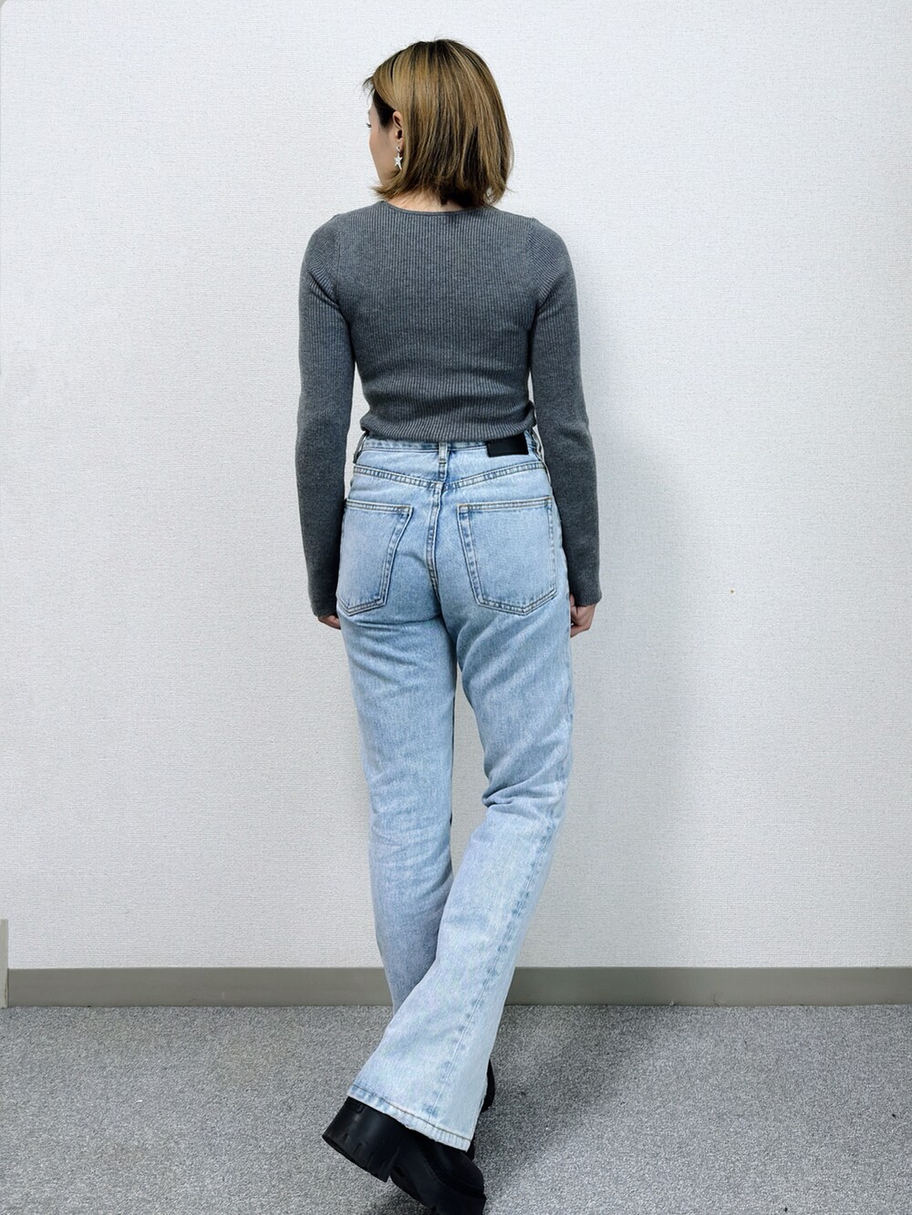 グレー系のニット/セーター、ブルー系のデニムパンツ、ブラック系のブーツを着用したレディースの冬コーディネートの5枚目の写真
