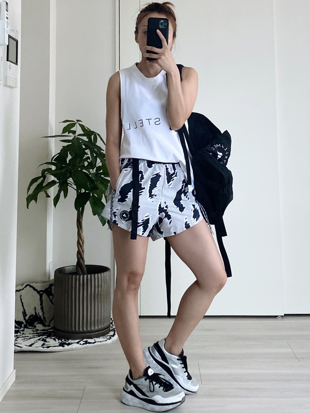 ブラック系のバックパック/リュック、その他のパンツ、ホワイト系のタンクトップを着用したレディースの夏コーディネートの2枚目の写真