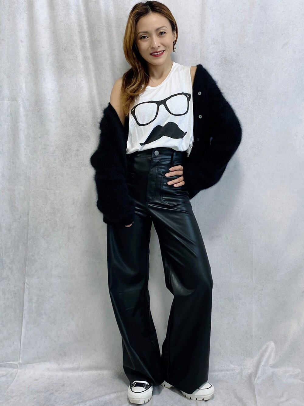 ブラック系のニット/セーター、ブラック系のパンツ、ブラック系のスニーカーを着用したレディースの秋コーディネートの3枚目の写真