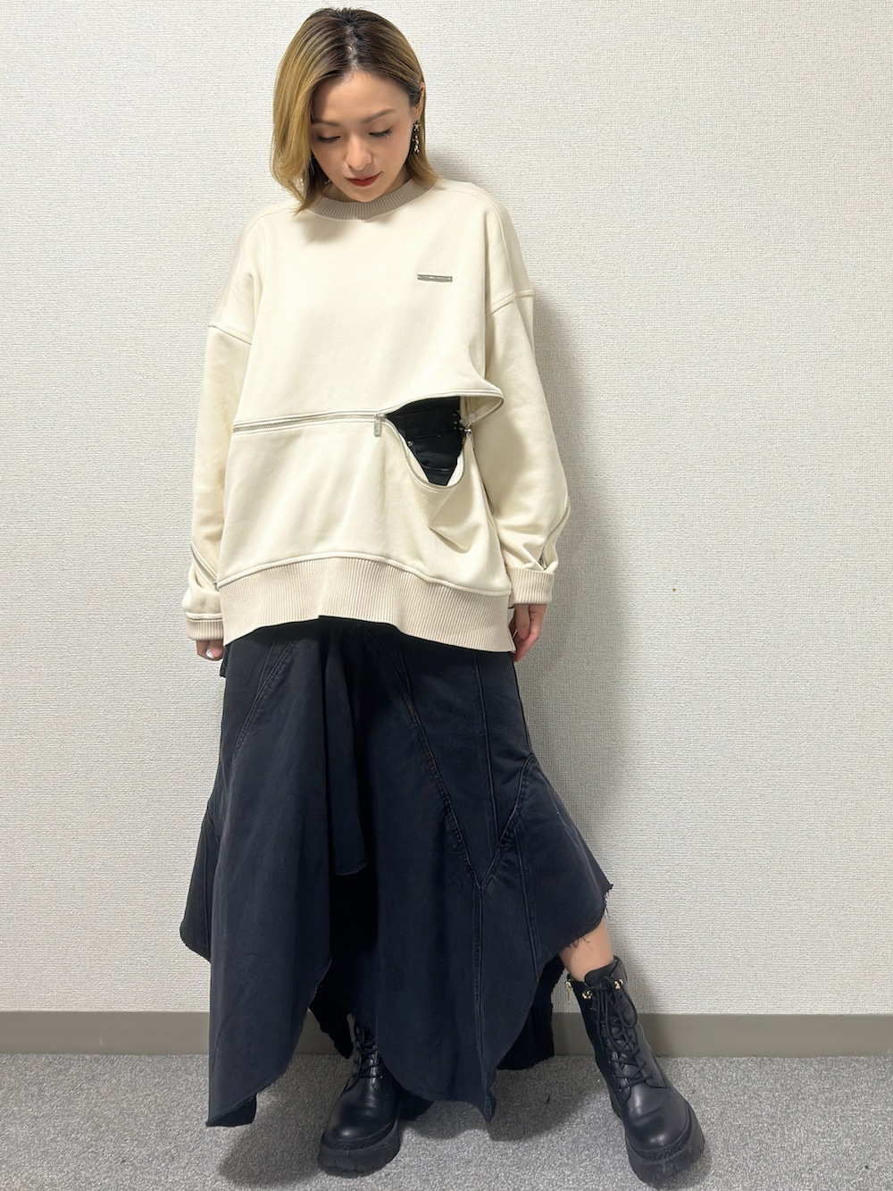 ホワイト系のニット/セーター、ブラック系のデニムスカート、ブラック系のブーツを着用したレディースの冬コーディネートの3枚目の写真