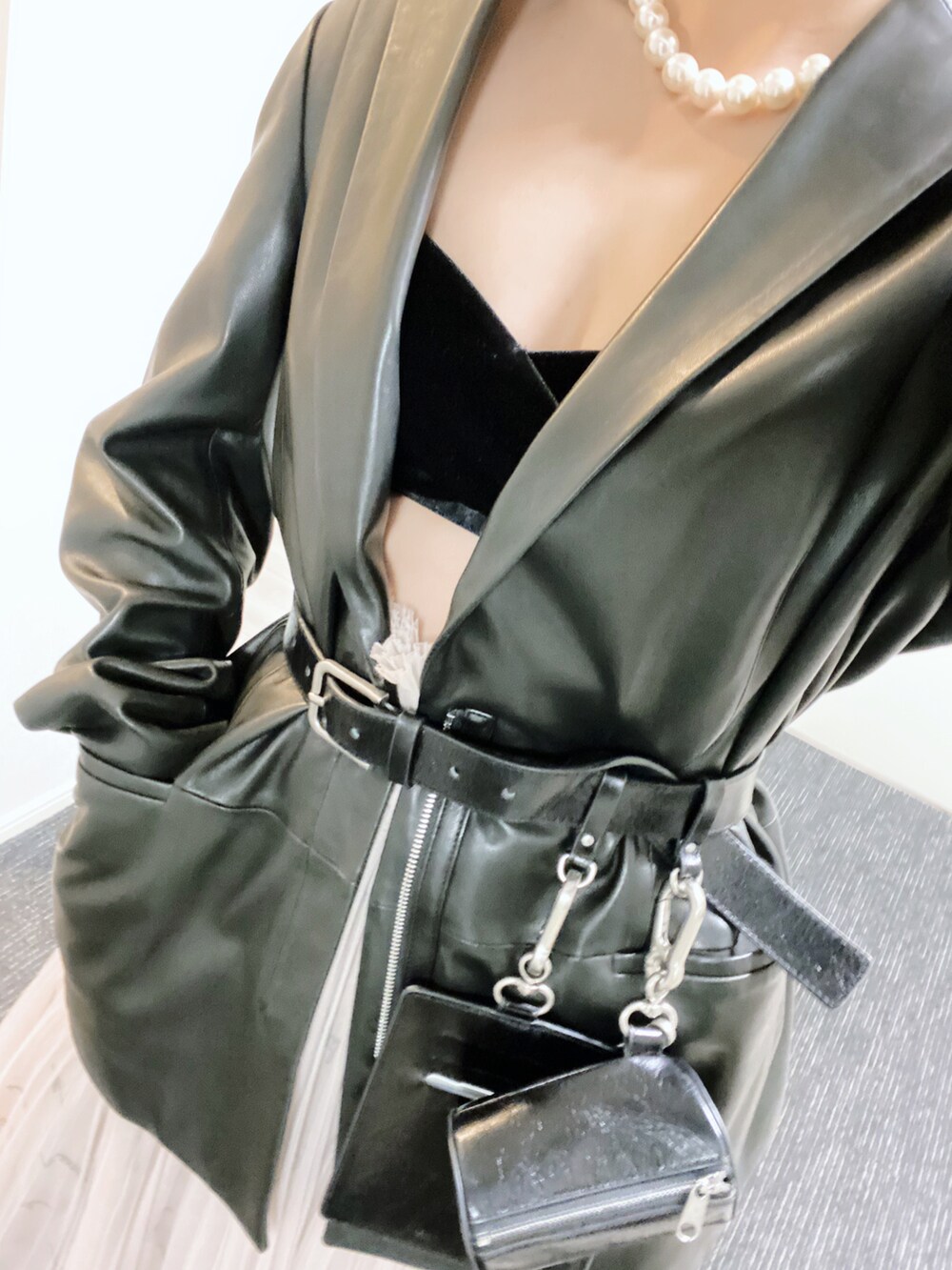 ブラック系のテーラードジャケット、ベージュ系のスカート、ブラック系のスニーカーを着用したレディースの冬コーディネートの4枚目の写真