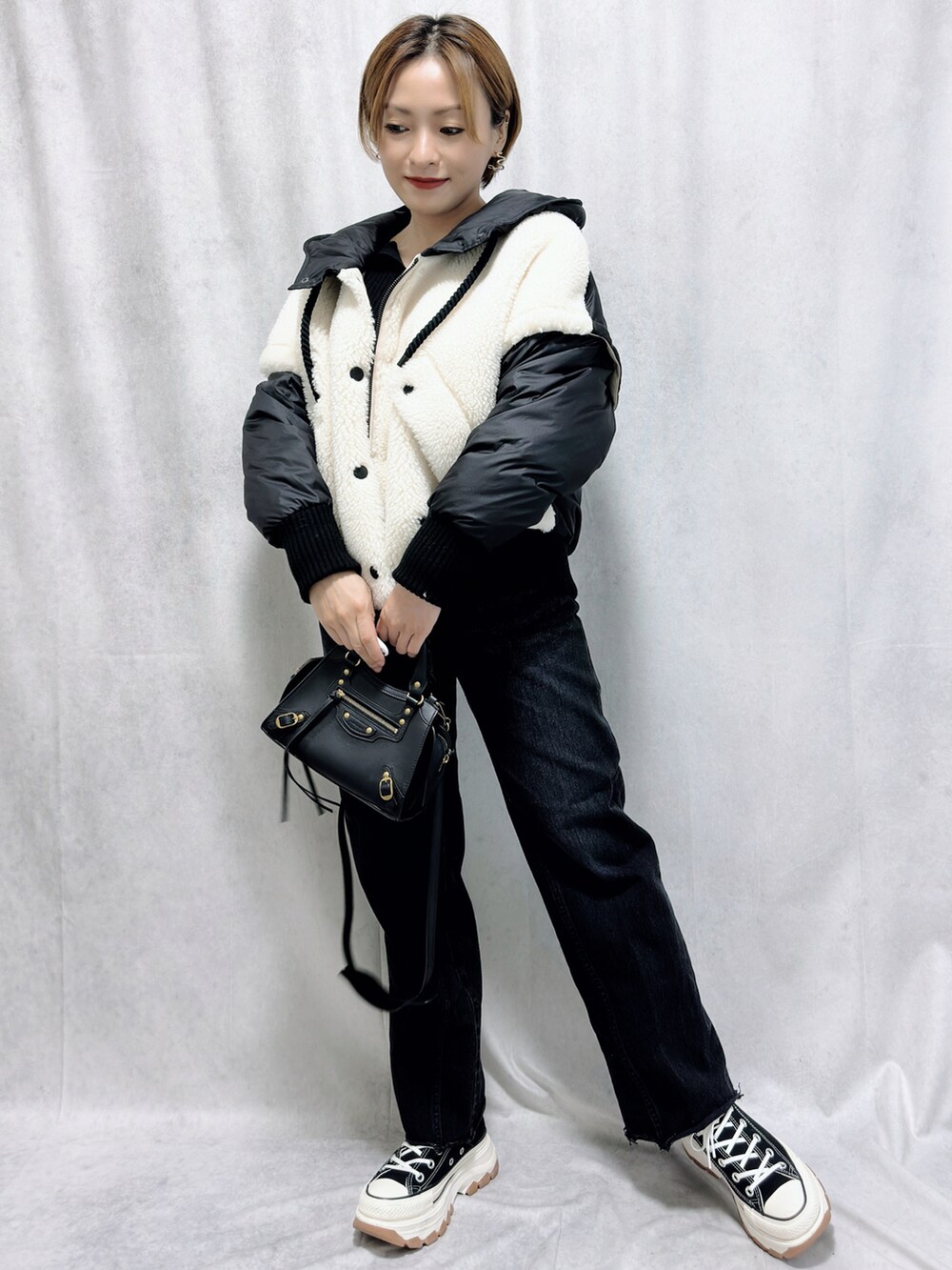 ブラック系のジャケット/アウター、ブラック系のバッグ、ブラック系のスニーカーを着用したレディースの冬コーディネートの2枚目の写真