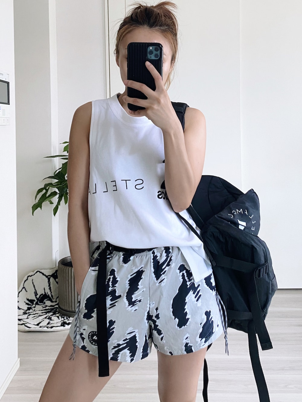 ブラック系のバックパック/リュック、その他のパンツ、ホワイト系のタンクトップを着用したレディースの夏コーディネートの3枚目の写真