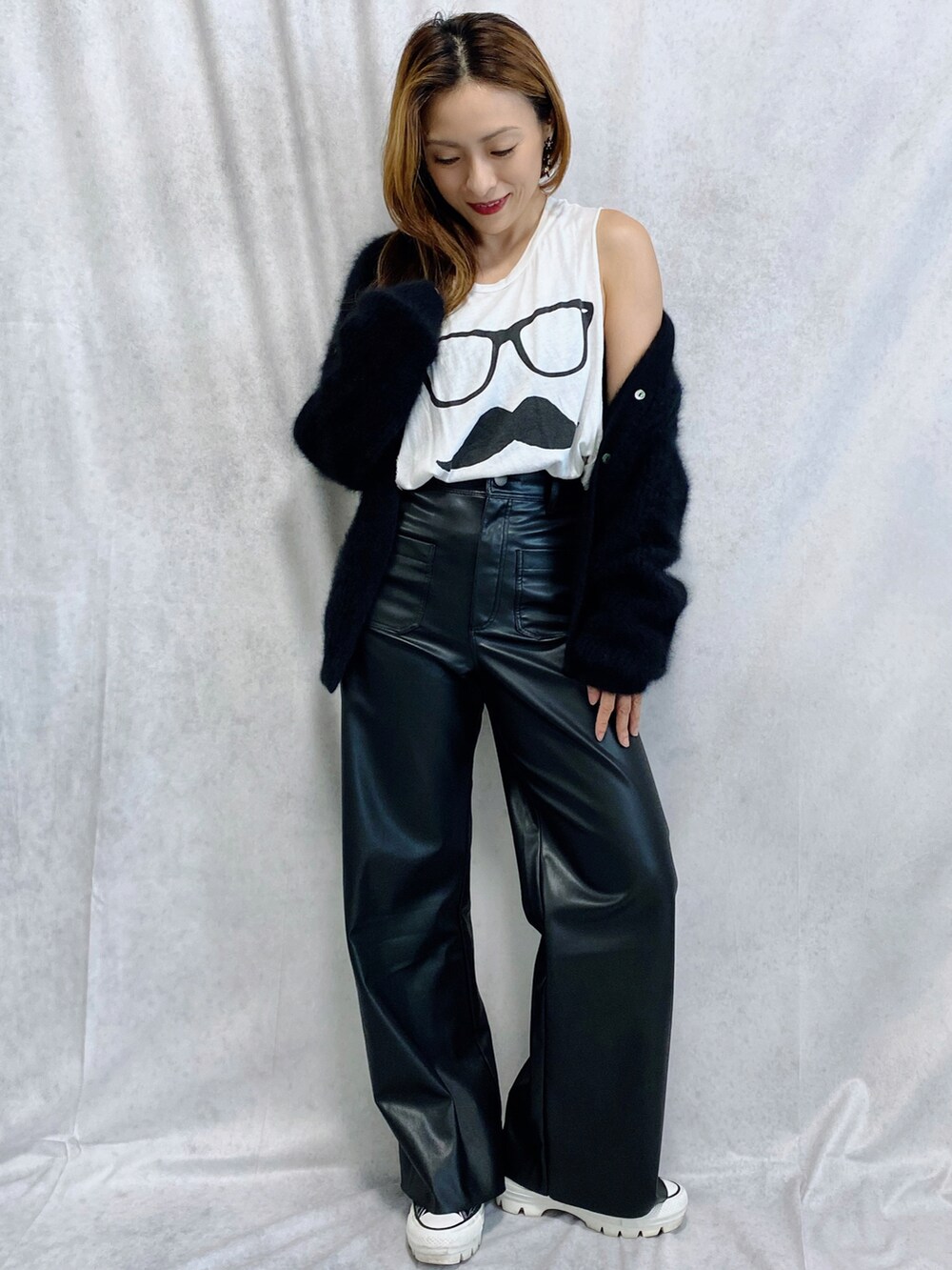 ブラック系のニット/セーター、ブラック系のパンツ、ブラック系のスニーカーを着用したレディースの秋コーディネートの2枚目の写真