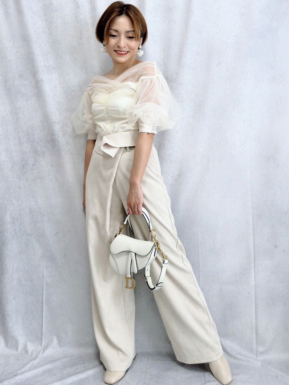 ホワイト系のTシャツ/カットソー、ホワイト系のその他パンツ、ホワイト系のバッグを着用したレディースの冬コーディネートの3枚目の写真