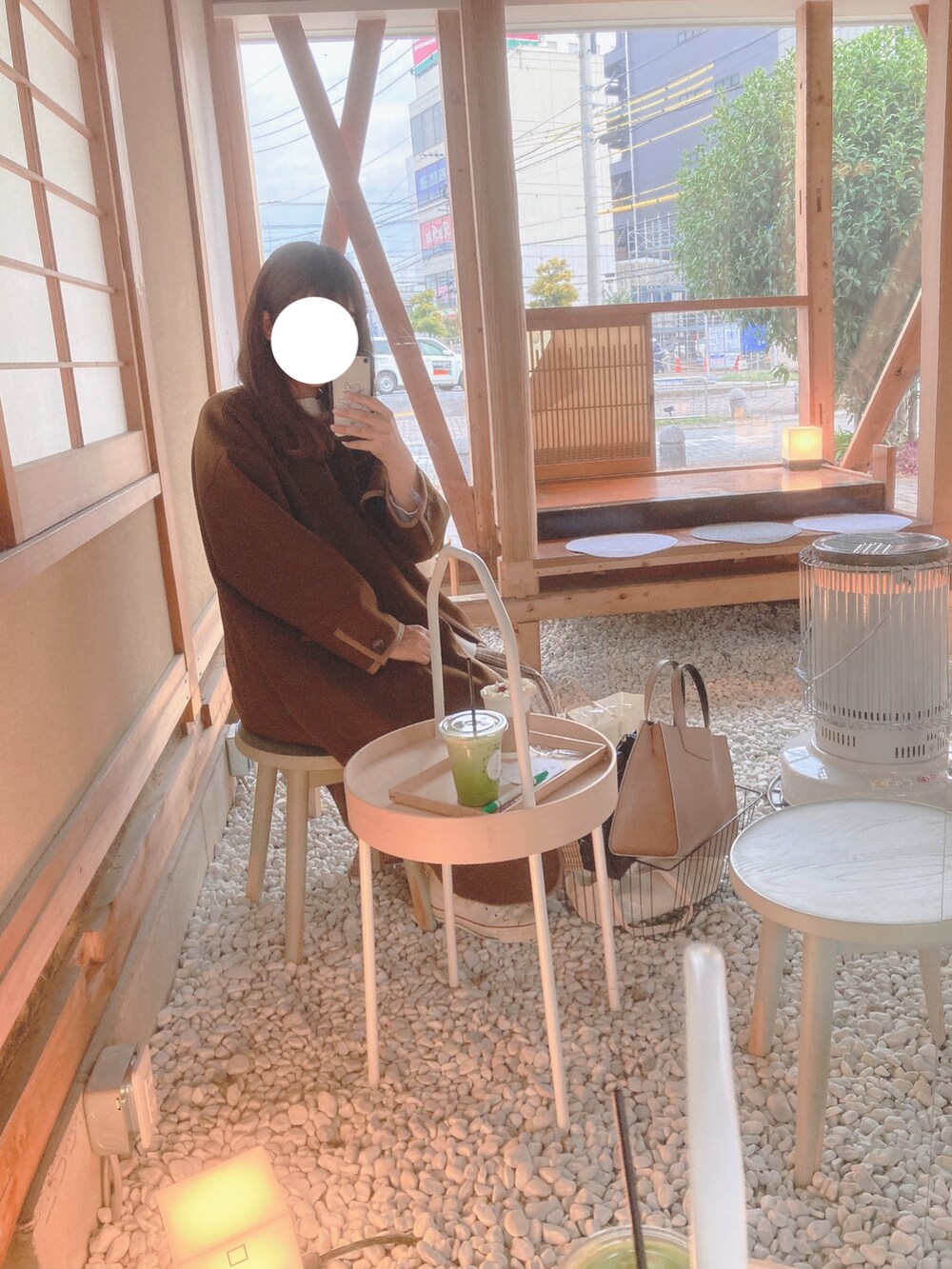 ブラウン系のノーカラーコート、ベージュ系のスカート、ホワイト系のトートバッグを着用したレディースの冬コーディネートの2枚目の写真