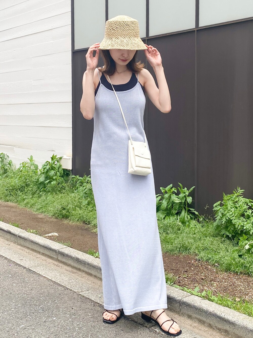 パープル系のワンピース、ブラック系のサンダル、ホワイト系のショルダーバッグを着用したレディースの春コーディネートの2枚目の写真