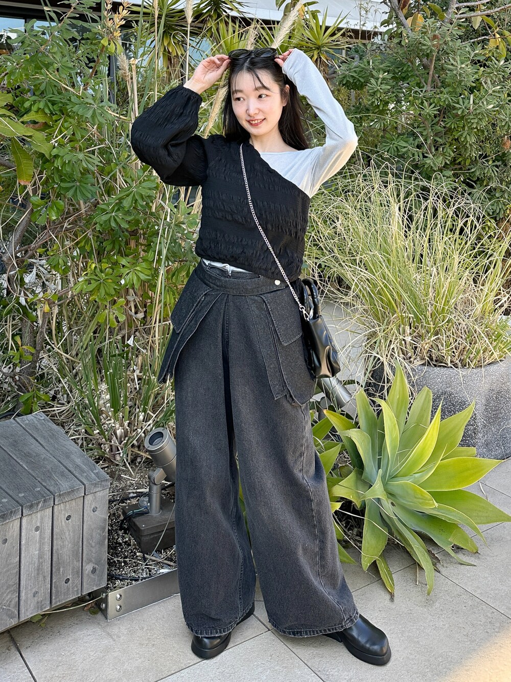 シルバー系のTシャツ/カットソー、ブラック系のベルト、ブラック系のサングラスを着用したレディースの春コーディネートの2枚目の写真