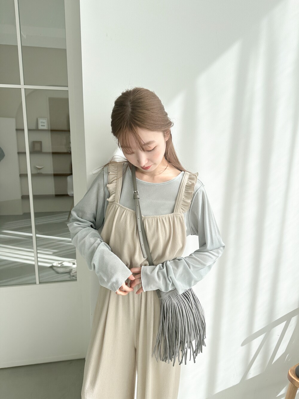 ホワイト系のサロペット/オーバーオール、ブルー系のTシャツ/カットソーを着用したレディースの春コーディネートの2枚目の写真