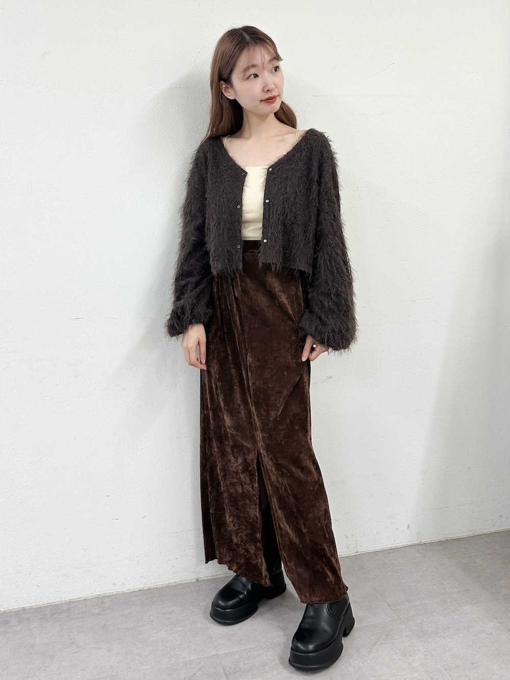 ブラウン系のカーディガン/ボレロ、ブラウン系のスカート、ホワイト系のキャミソールを着用したレディースの秋コーディネートの2枚目の写真