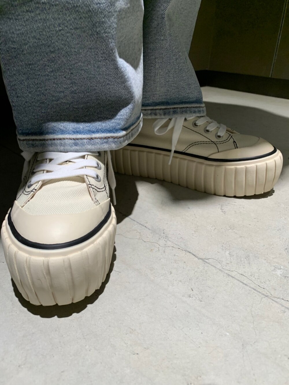 ブルー系のデニムパンツ、オレンジ系のニット/セーター、ブラウン系のジャケット/アウターを着用したレディースの秋コーディネートの3枚目の写真