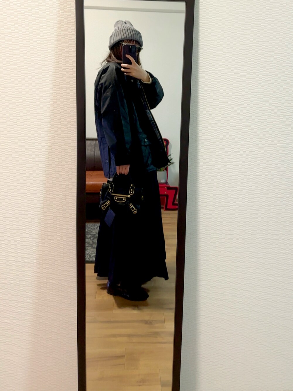 ブラック系のジャケット/アウター、ベージュ系のニット/セーター、ブラック系のバッグを着用したレディースの冬コーディネートの2枚目の写真