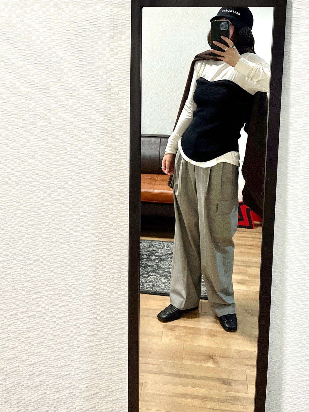 ブラウン系のニット/セーター、ブラック系のトップス、ブラウン系のバッグを着用したレディースの秋コーディネートの3枚目の写真