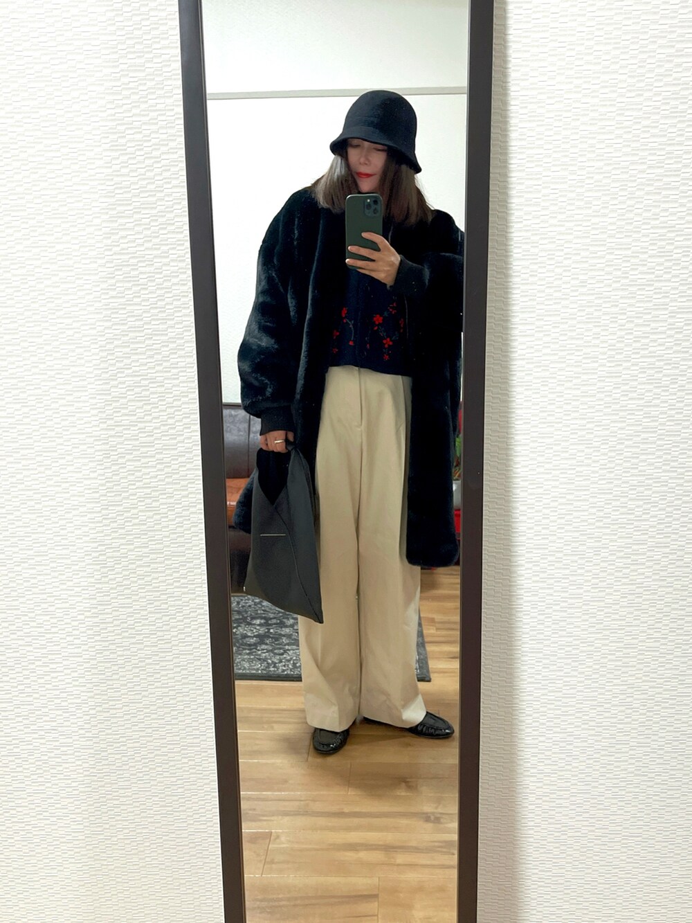 ブラック系のジャケット/アウター、ブラック系のバッグ、ベージュ系のパンツを着用したレディースの冬コーディネートの2枚目の写真