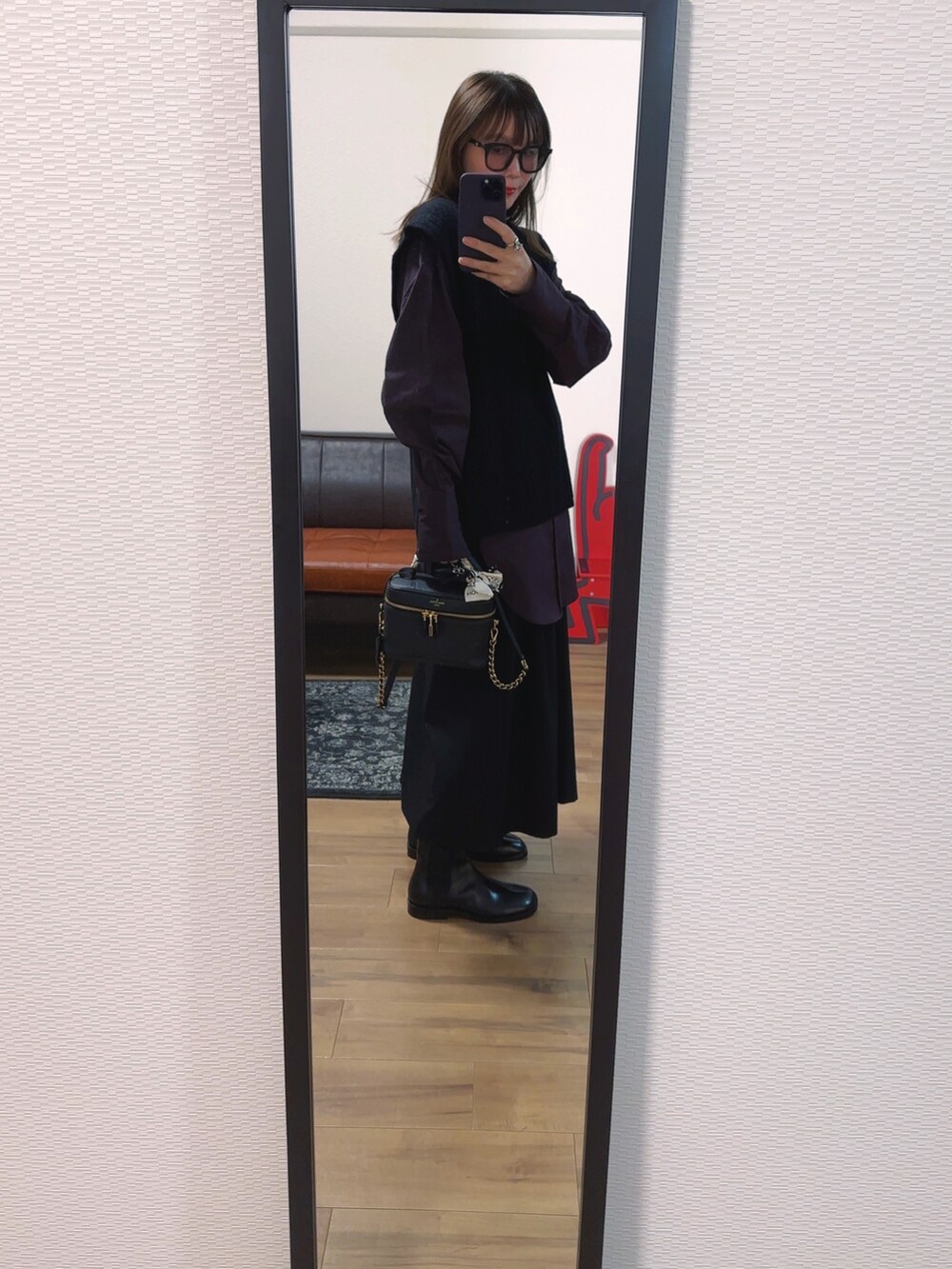 ブラック系のベスト、パープル系のシャツ/ブラウス、ブラック系のバッグを着用したレディースの秋コーディネートの2枚目の写真