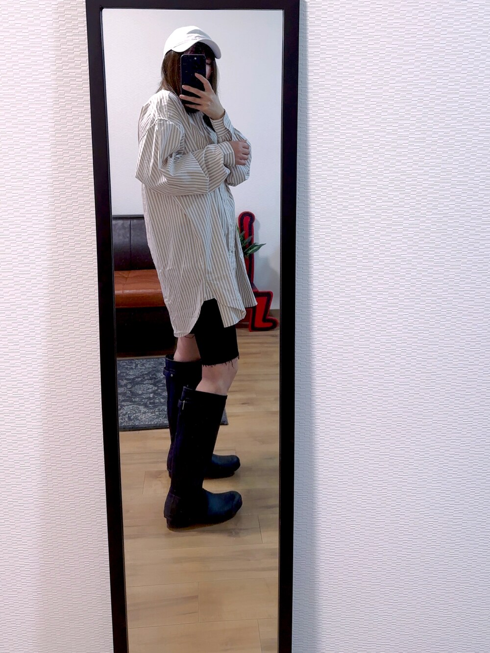 ベージュ系のシャツ/ブラウス、ブラック系のデニムパンツ、ブラック系のブーツを着用したレディースの春コーディネートの2枚目の写真