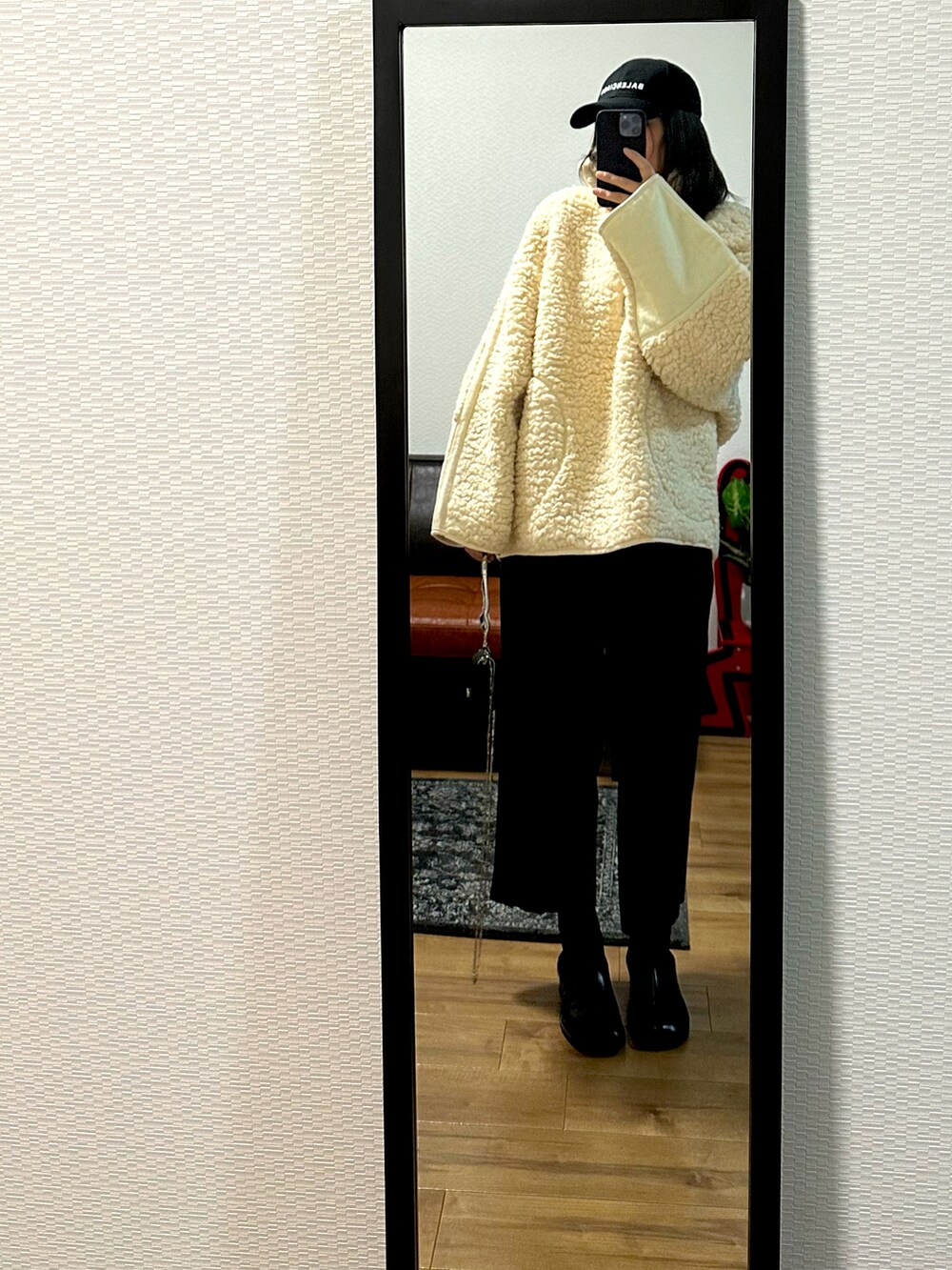 ホワイト系のジャケット/アウター、ブラック系のブーツ、ブラック系のパンツを着用したレディースの秋コーディネートの3枚目の写真