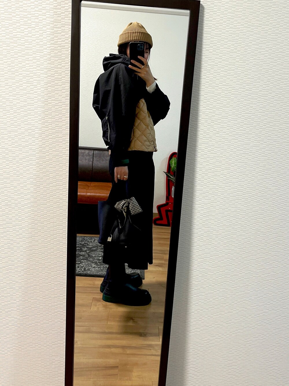 ブラック系のジャケット/アウター、ベージュ系のベスト、ブラック系のパンツを着用したレディースの秋コーディネートの2枚目の写真