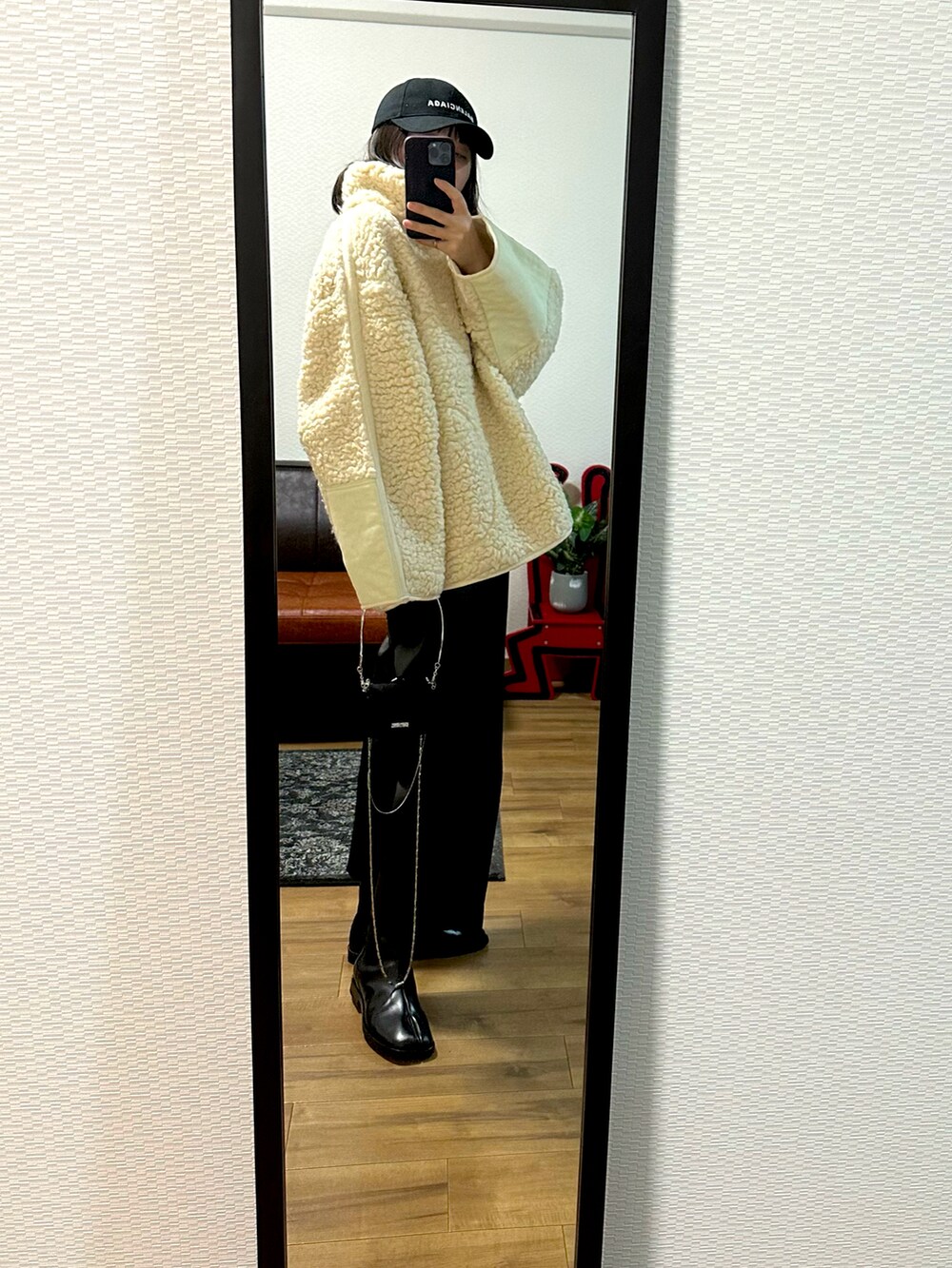 ホワイト系のジャケット/アウター、ブラック系のブーツ、ブラック系のパンツを着用したレディースの秋コーディネートの2枚目の写真