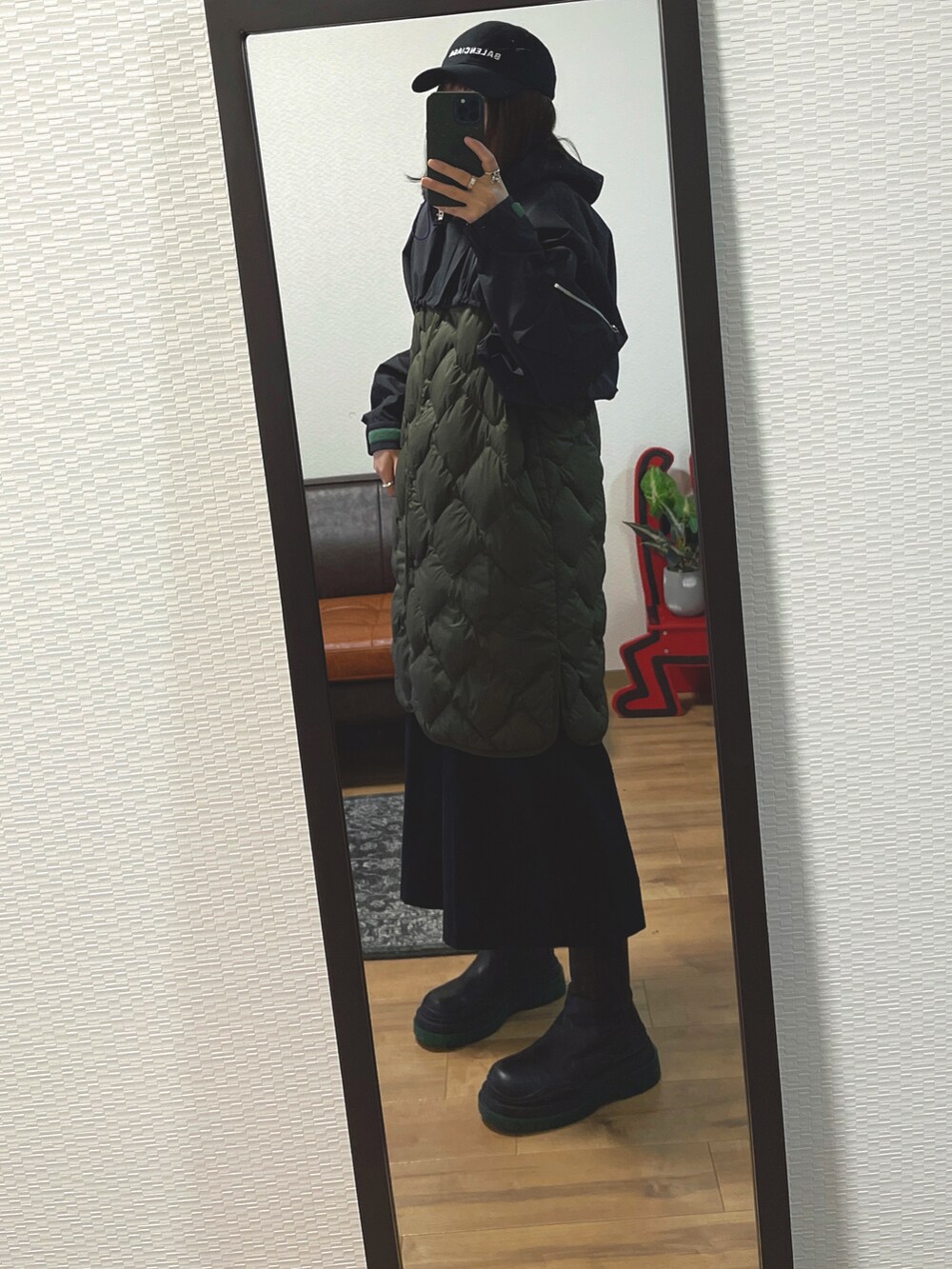 グリーン系のダウンベスト、ブラック系のジャケット/アウター、ブラック系のバッグを着用したレディースの冬コーディネートの2枚目の写真
