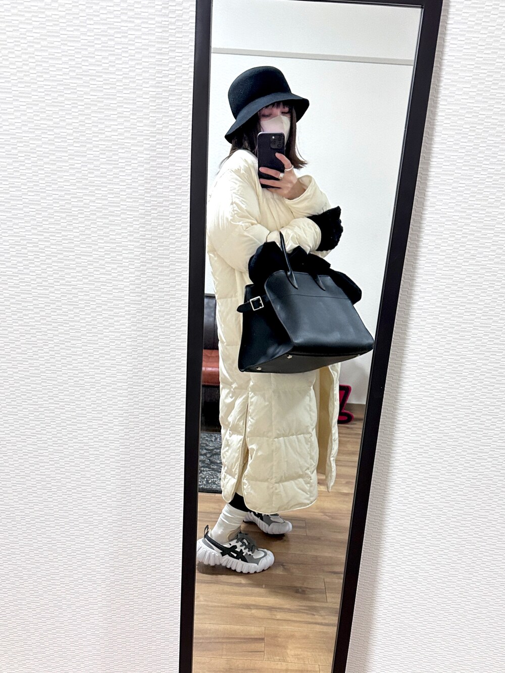 ホワイト系のジャケット/アウター、ブラック系のバッグ、ベージュ系のワンピースを着用したレディースの冬コーディネートの2枚目の写真