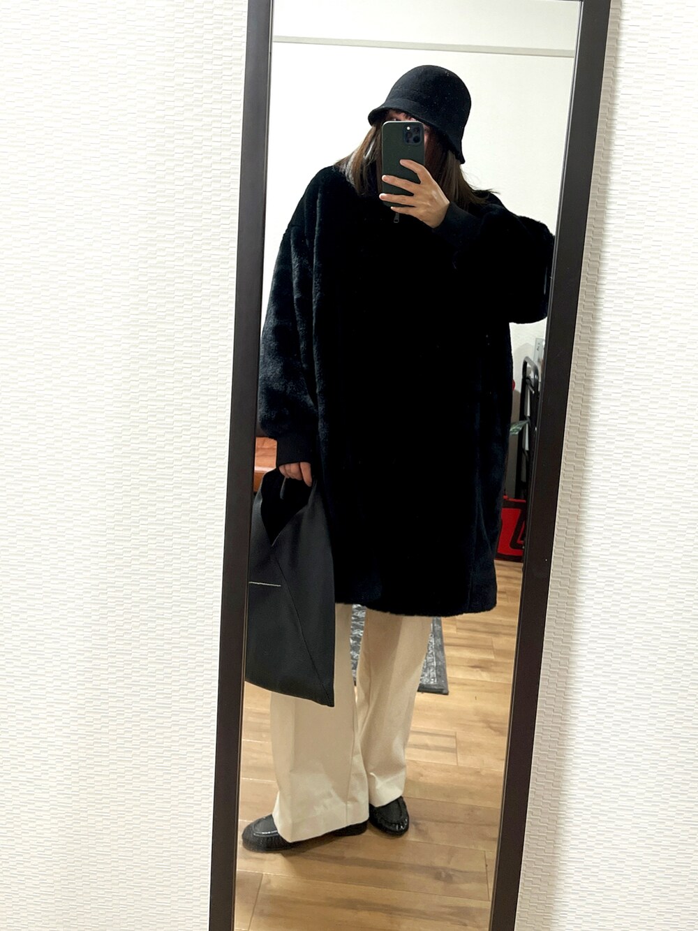 ブラック系のジャケット/アウター、ブラック系のバッグ、ベージュ系のパンツを着用したレディースの冬コーディネートの3枚目の写真