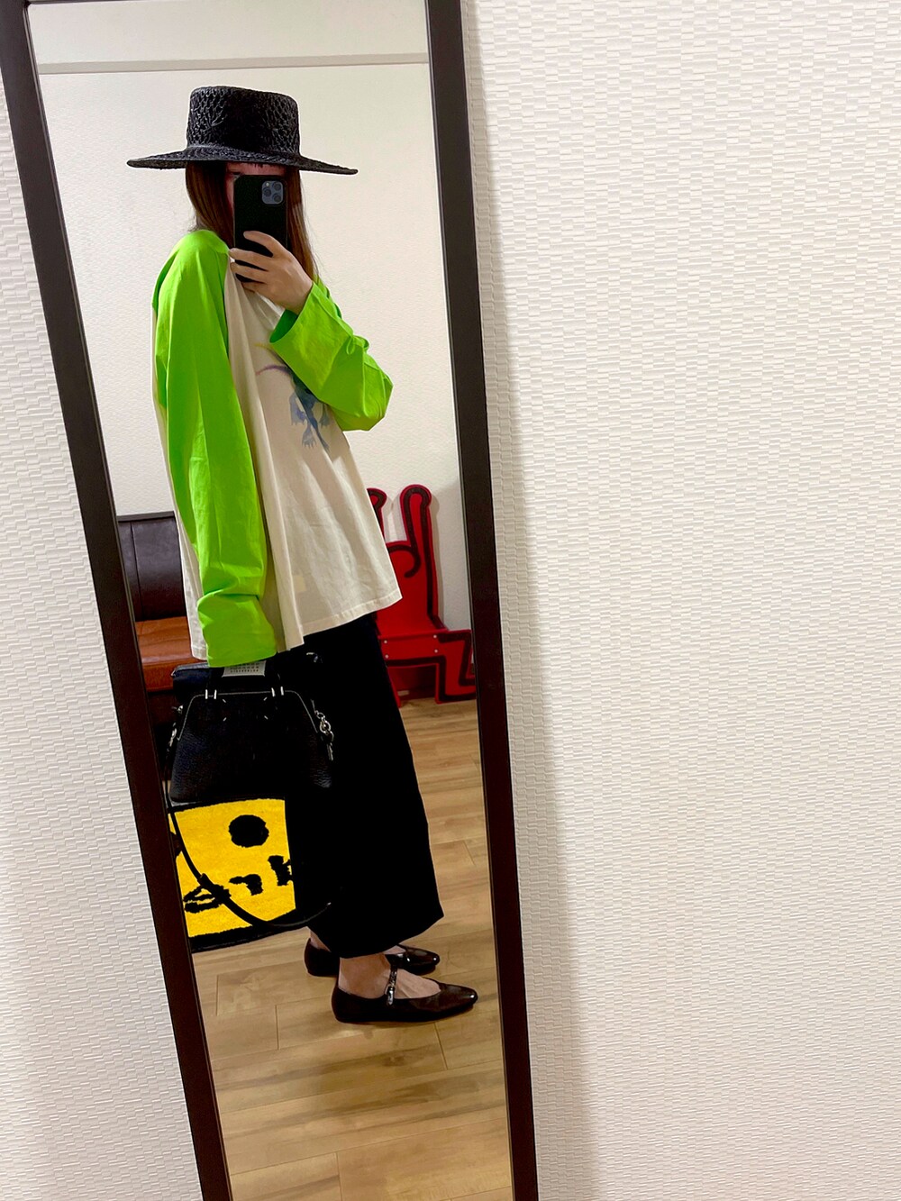 ブラック系のバッグ、グリーン系のTシャツ/カットソー、ブラック系のスカートを着用したレディースの夏コーディネートの2枚目の写真