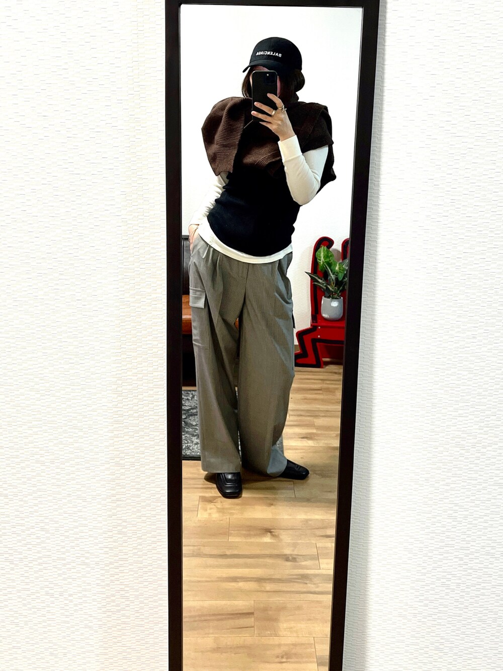 ブラウン系のニット/セーター、ブラック系のトップス、ブラウン系のバッグを着用したレディースの秋コーディネートの2枚目の写真