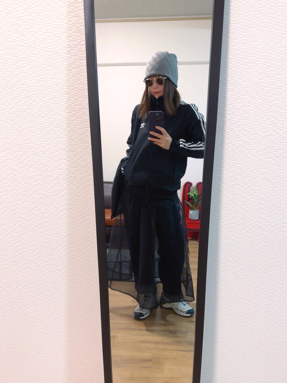 ブラック系のトップス、ブラック系のバッグ、ブラック系のスカートを着用したレディースの春コーディネートの2枚目の写真