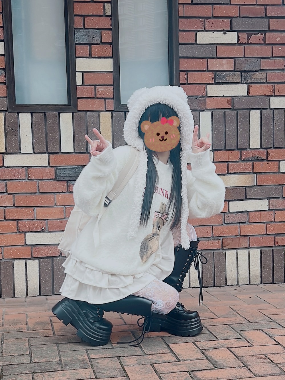 ホワイト系のニット/セーター、ホワイト系のスカート、ブラック系のブーツを着用したレディースの秋コーディネートの3枚目の写真