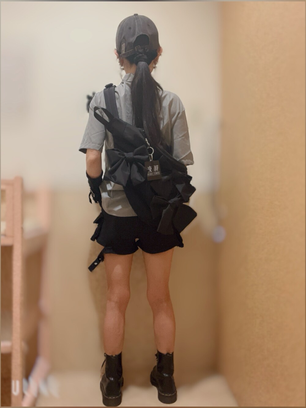 ブラック系のショルダーバッグ、ブラック系のブーツ、ブラック系のデニムパンツを着用したレディースの夏コーディネートの2枚目の写真