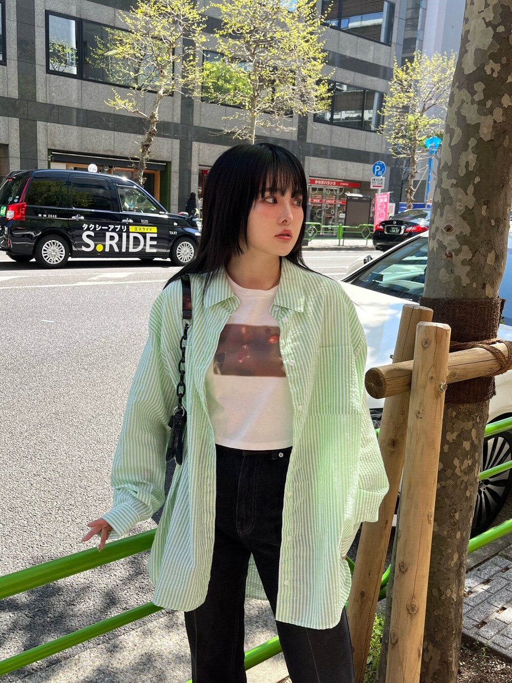 ブラック系のデニムパンツ、ホワイト系のTシャツ/カットソー、グリーン系のシャツ/ブラウスを着用したレディースの春コーディネートの2枚目の写真