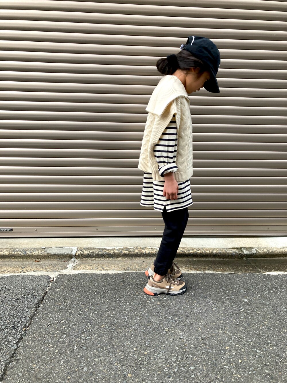 ブラック系のスウェットパンツ、ホワイト系のベスト、ブラック系のキャップを着用したキッズの冬コーディネートの3枚目の写真