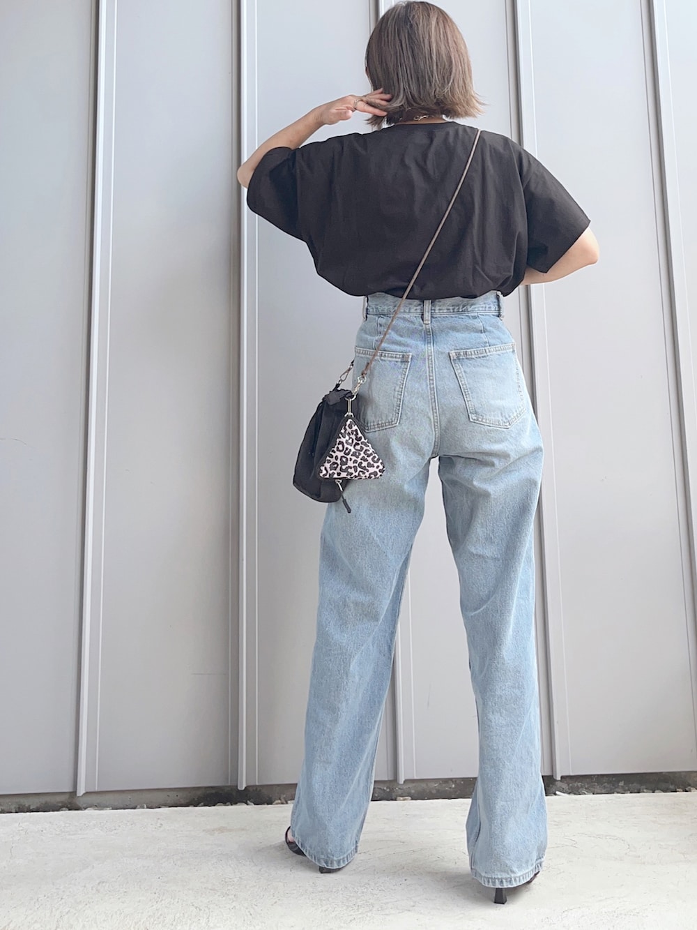 ブラック系のTシャツ/カットソー、ブルー系のデニムパンツ、ブラック系のショルダーバッグを着用したレディースの夏コーディネートの3枚目の写真