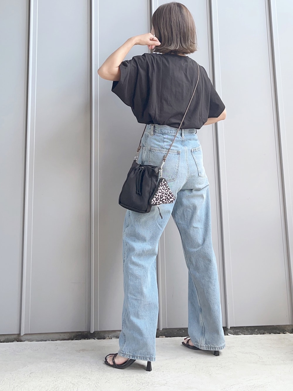 ブラック系のTシャツ/カットソー、ブルー系のデニムパンツ、ブラック系のショルダーバッグを着用したレディースの夏コーディネートの4枚目の写真