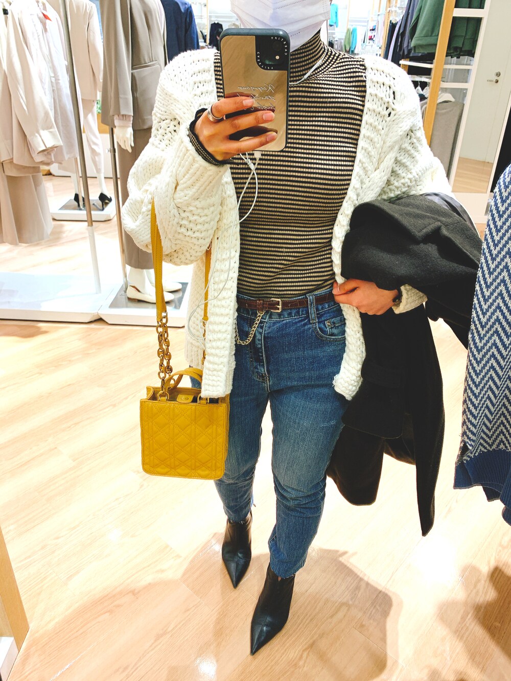 ブラウン系のその他アウター、ホワイト系のカーディガン/ボレロ、ブラウン系のニット/セーターを着用したレディースの冬コーディネートの2枚目の写真