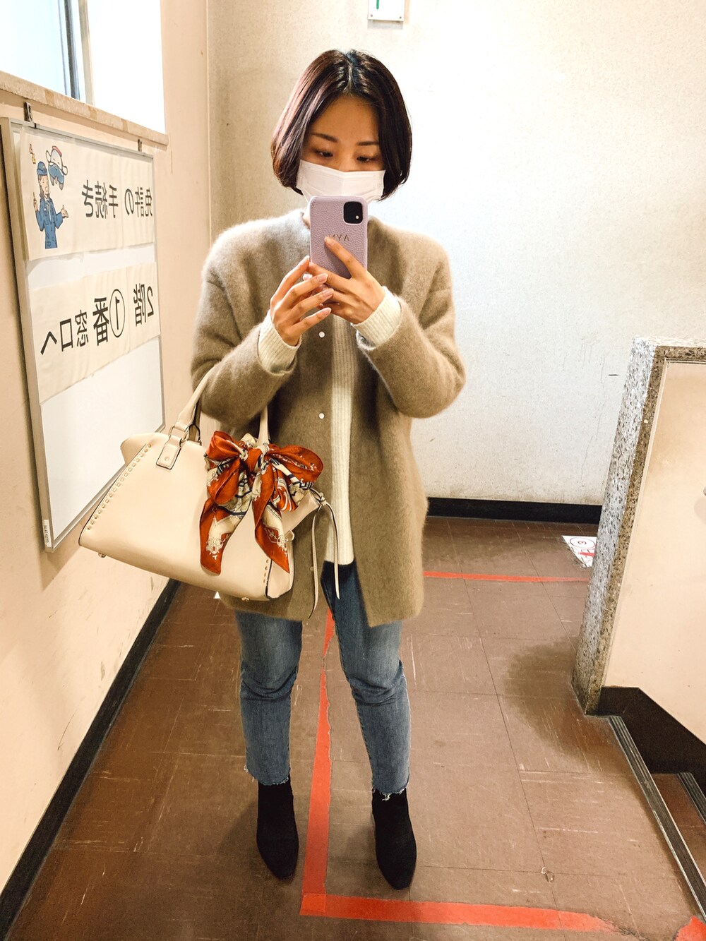ベージュ系のジャケット/アウター、ホワイト系のニット/セーター、グレー系のデニムパンツを着用したレディースの冬コーディネートの2枚目の写真