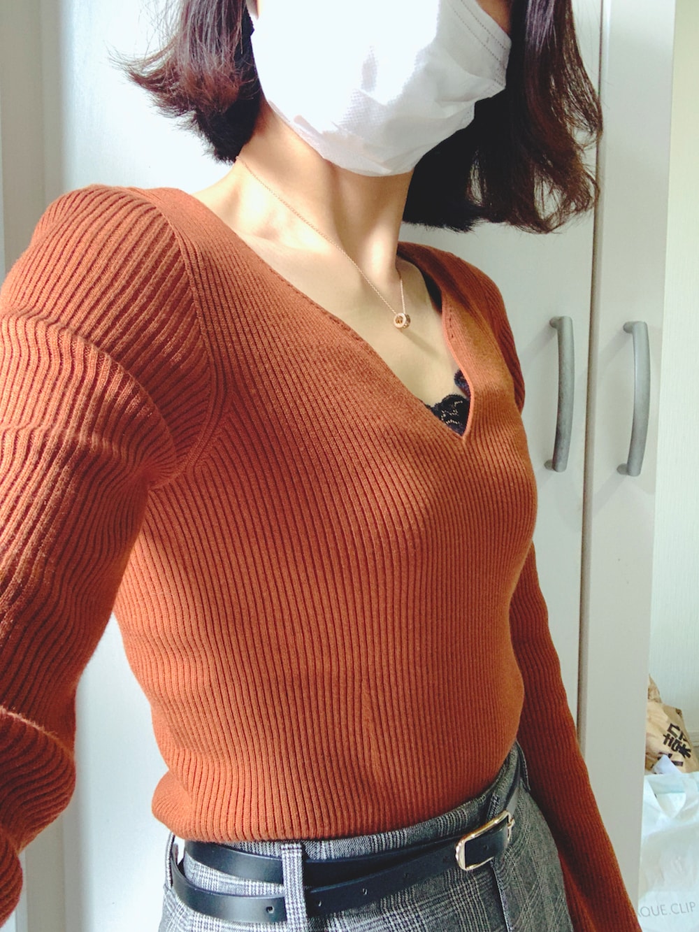 グレー系のパンツ、ブラック系のパンプス、ブラウン系のニット/セーターを着用したレディースの秋コーディネートの2枚目の写真