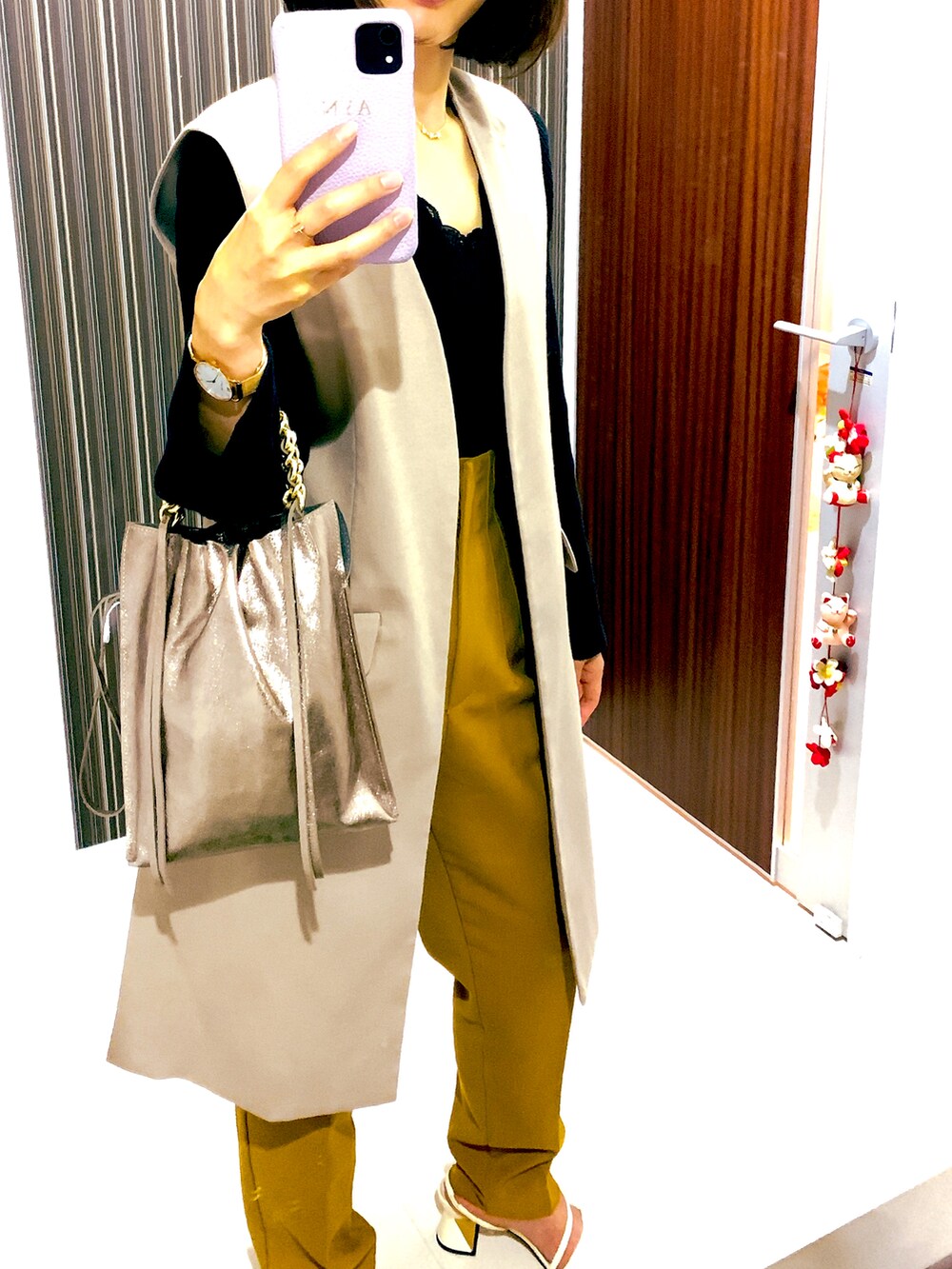 ブラック系のニット/セーター、イエロー系のパンツ、ベージュ系のジャケット/アウターを着用したレディースの秋コーディネートの2枚目の写真