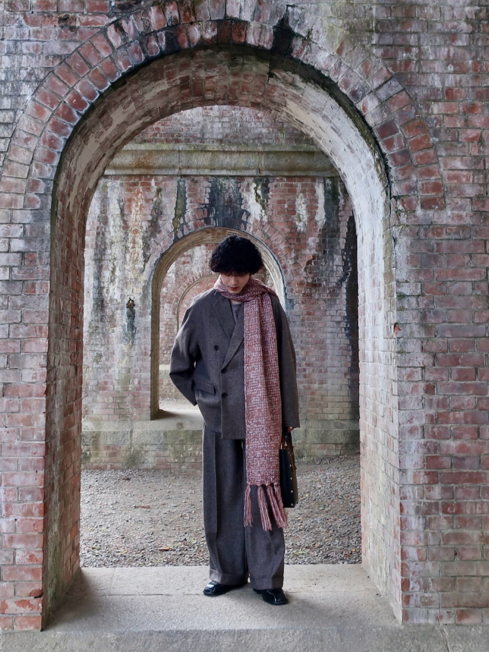 グレー系のテーラードジャケット、グレー系のスラックス、その他のブーツを着用したメンズの冬コーディネートの5枚目の写真