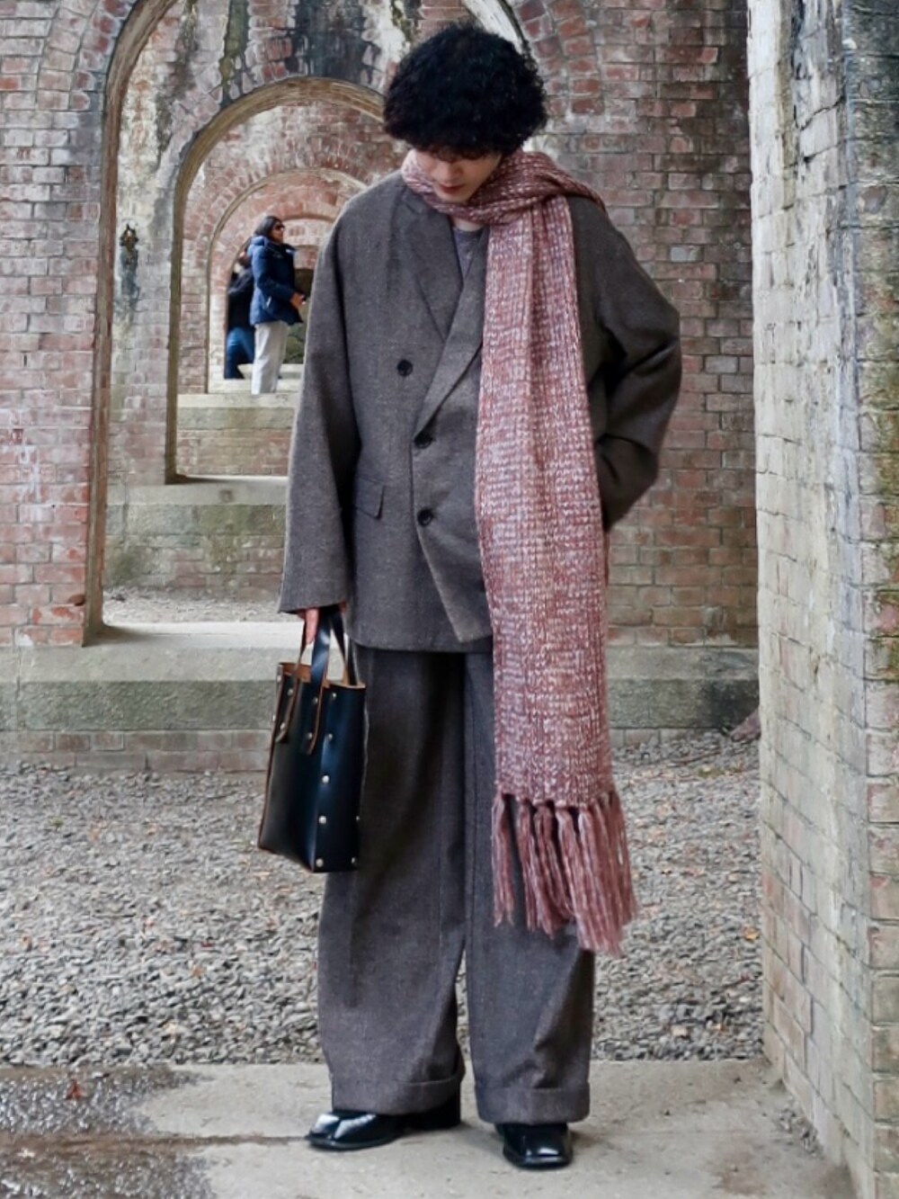 グレー系のテーラードジャケット、グレー系のスラックス、その他のブーツを着用したメンズの冬コーディネートの2枚目の写真