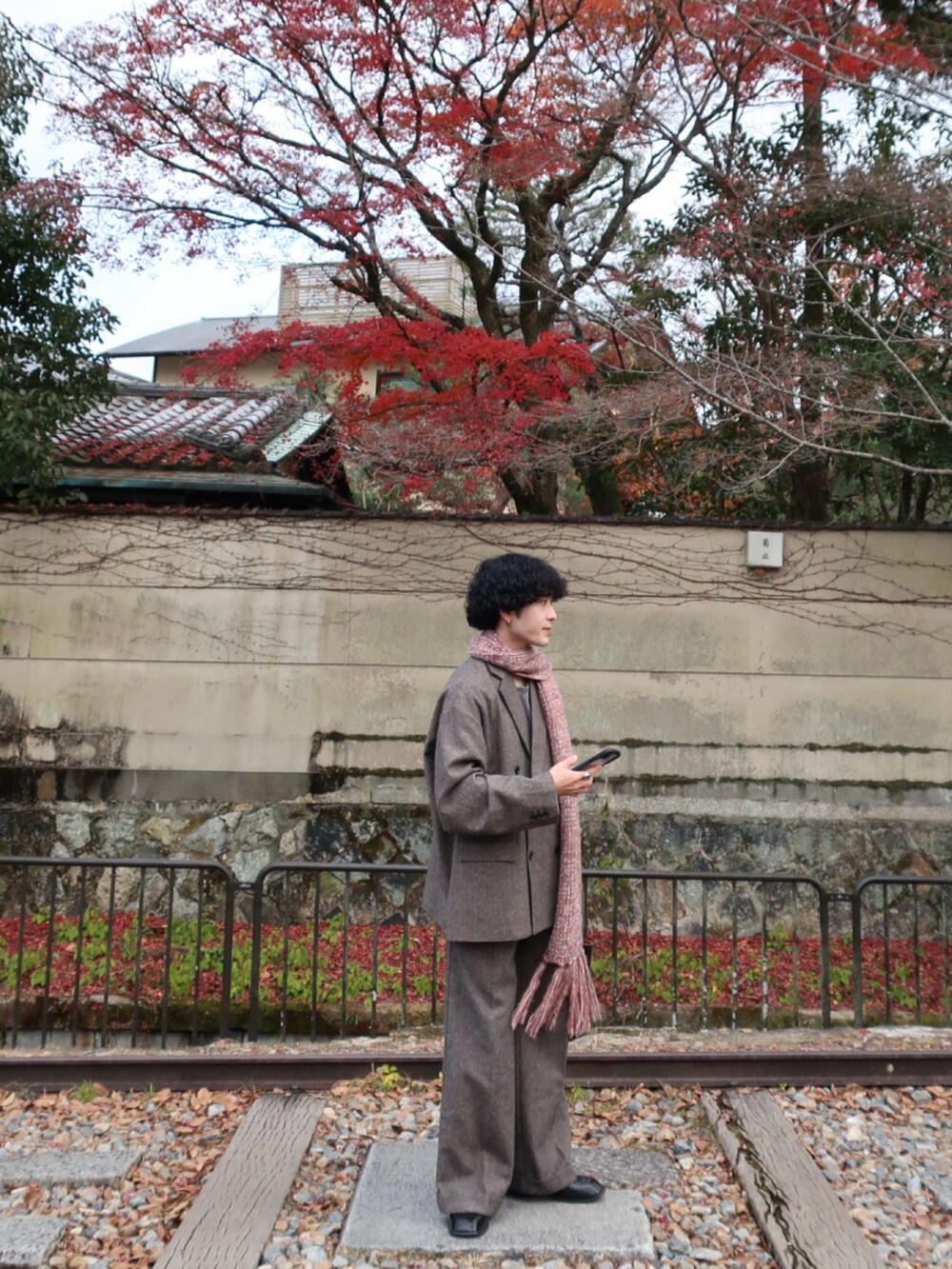 グレー系のテーラードジャケット、グレー系のスラックス、その他のブーツを着用したメンズの冬コーディネートの5枚目の写真