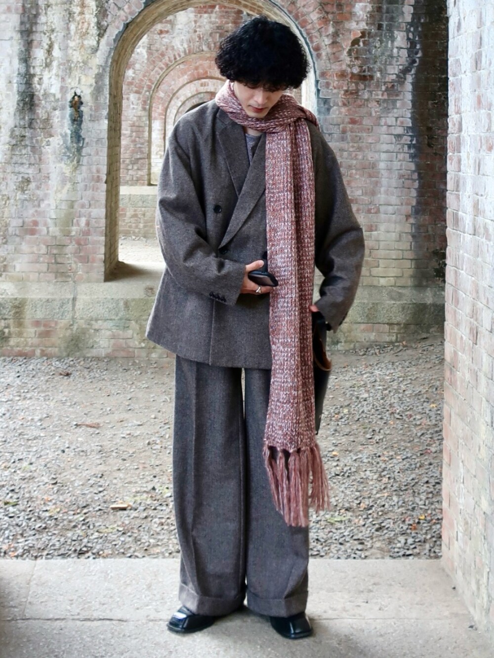 グレー系のテーラードジャケット、グレー系のスラックス、その他のブーツを着用したメンズの冬コーディネートの4枚目の写真