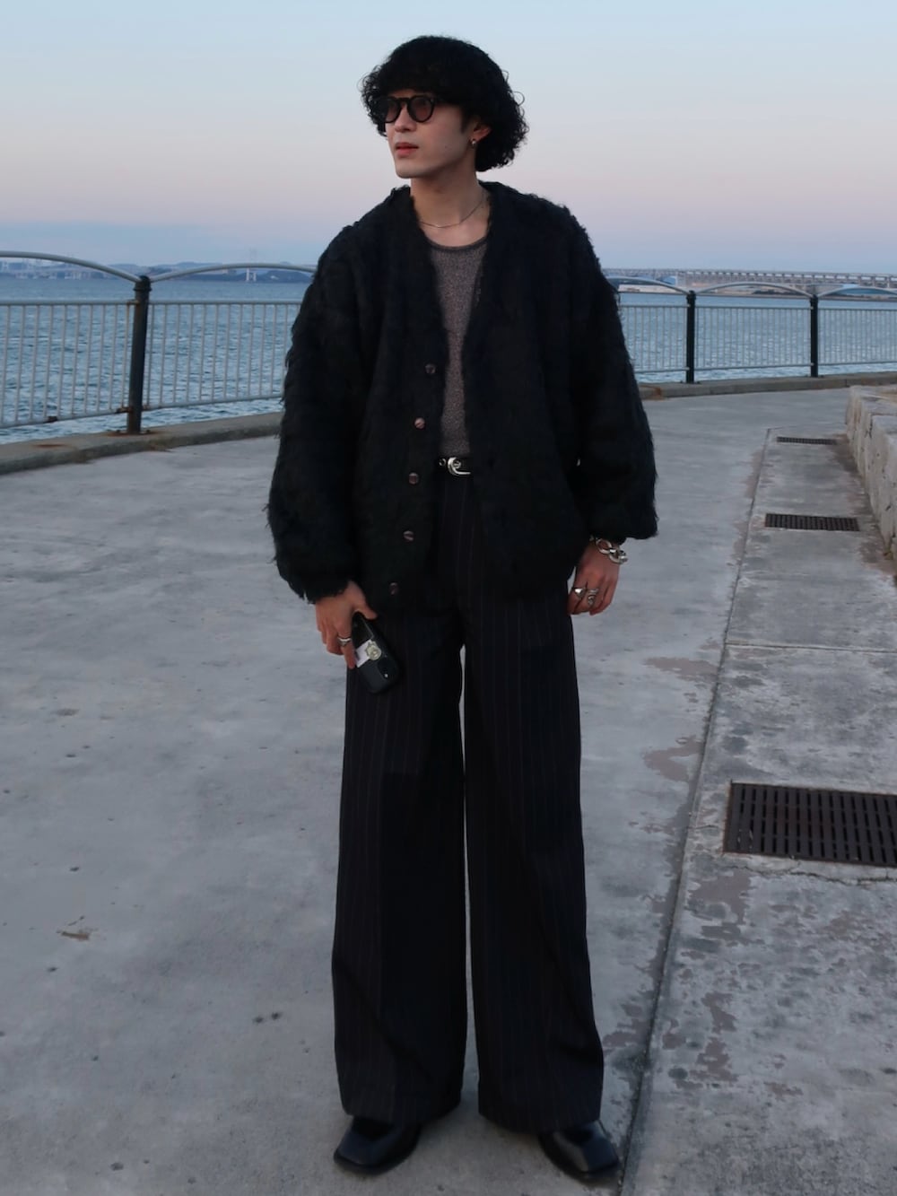 ブラック系のカーディガン/ボレロ、ブラック系のスラックス、その他のブーツを着用したメンズの冬コーディネートの2枚目の写真