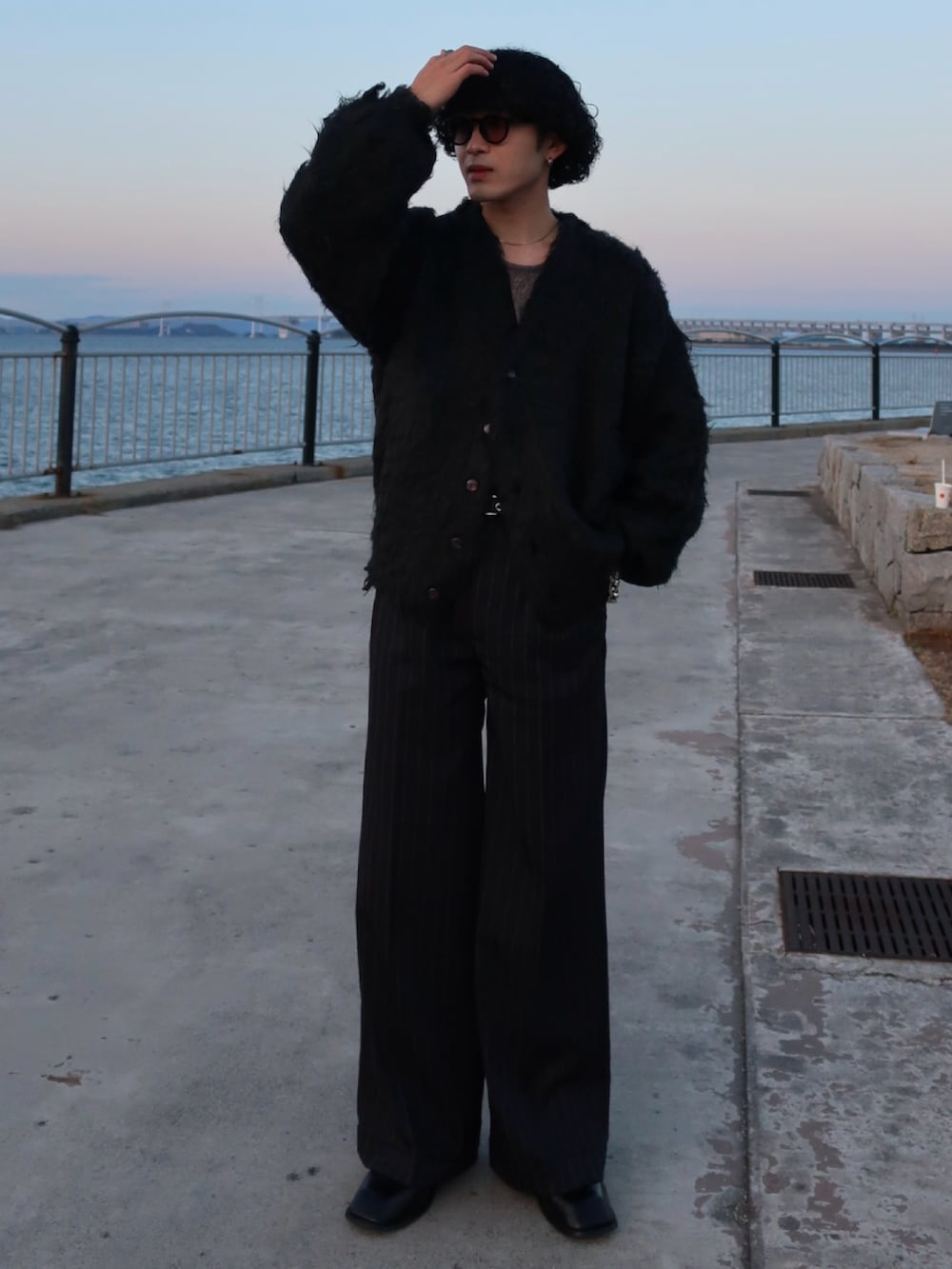 ブラック系のカーディガン/ボレロ、ブラック系のスラックス、その他のブーツを着用したメンズの冬コーディネートの3枚目の写真